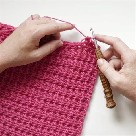 someone crocheting using red yarn