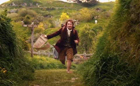 Bilbo Baggins running with a map in his hand