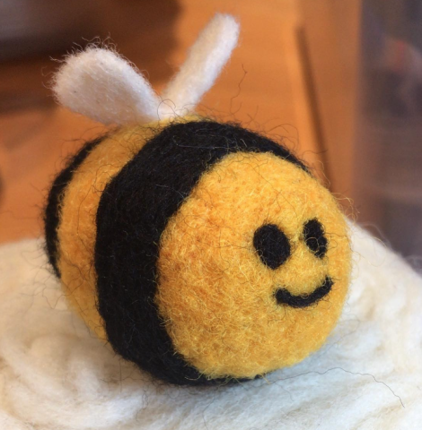 A bumblee made out of yellow and black felt