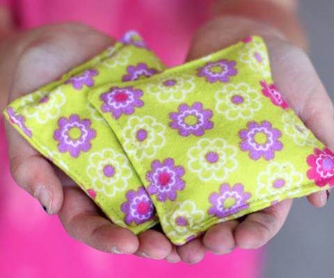 Woman holding a pair of hand-sewn hand warmers