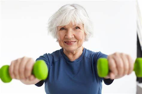 an older lady with white hair holding weights