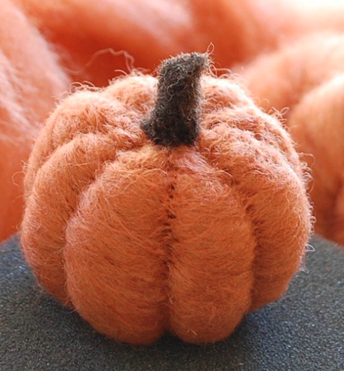 A small pumpkin made out of orange felt