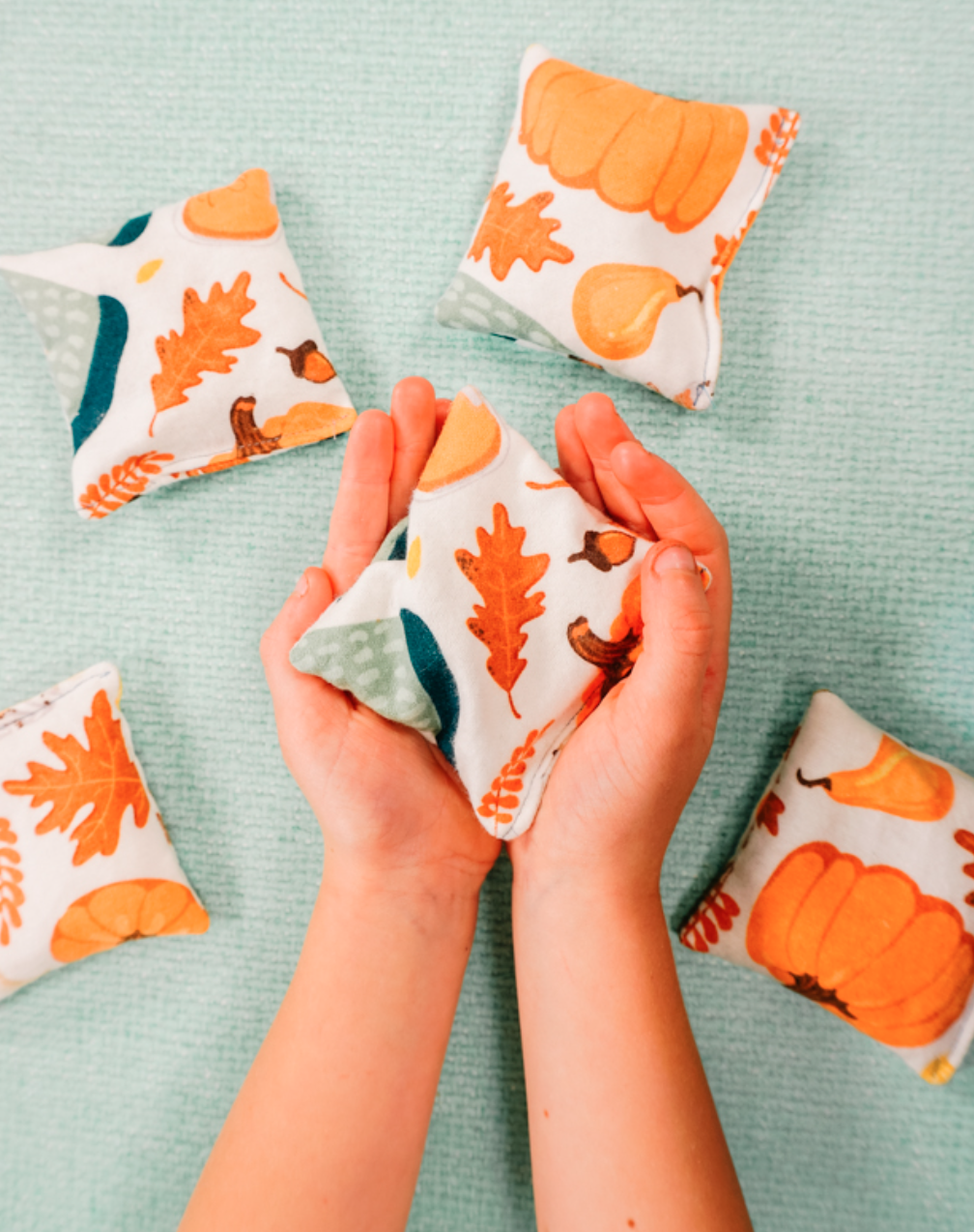 Hands holding a handwarmer with a pattern of fall leaves