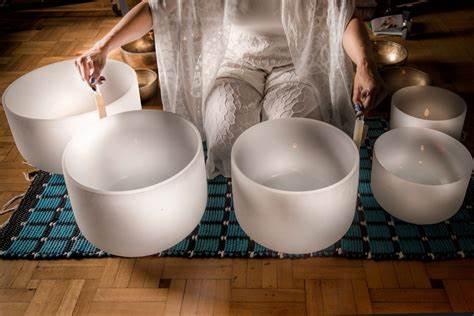 a lady playing crystal bowls